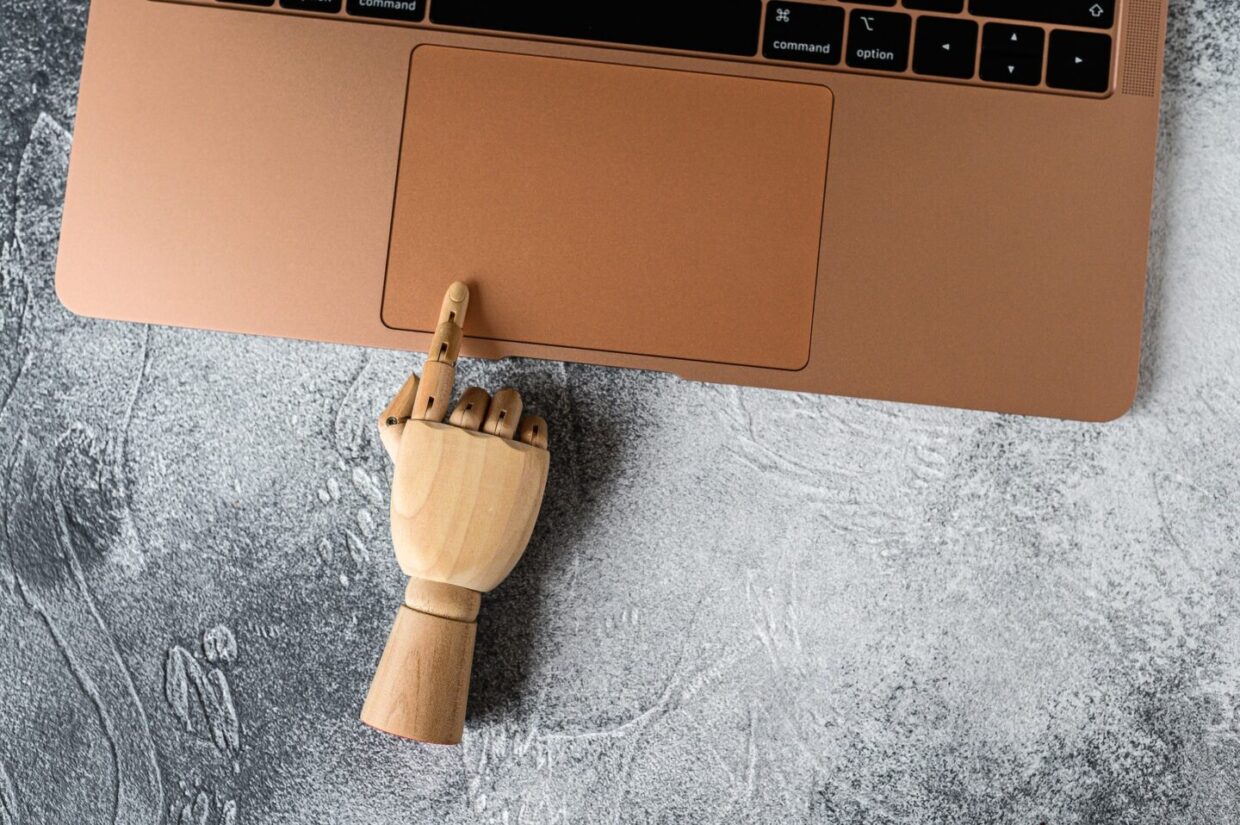 Wooden hand working at a laptop. Concept of communication and work in the office.
